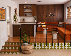 Modern Taurus constellation light fixture in matte black, shown in a retro sitting area with wood paneling, vintage bar cabinetry, and warm orange sofa. Statement wall sconce lighting that reads like modern wall art in a den, game room, or home bar.