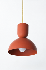 Terra cotta is the warm clay tone that makes a kitchen feel earthy, grounded, and a little sun-baked, and this Taeuber pendant carries it in a soft matte finish. The two-part silhouette stacks a rounded cup over a wide domed bell, all in a chalky terra cotta with a warm brass stem. The flat finish reads natural and understated, the kind of light that warms up an island, breakfast nook, or sink without any shine. Hang one for a hit of earthy color or a row for gentle rhythm. A lovely choice for an organic mo