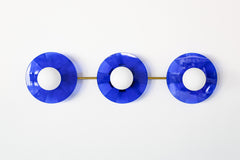Bright Blue Triple Circus Sconce: Bold and dazzling, the Bright Blue Triple Circus Sconce captures the essence of Murano glass with its vibrant blue acrylic disc. Each intricately etched disc casts mesmerizing light and shadow patterns, transforming your walls into a captivating display.