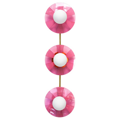 Infuse your space with playful energy with the Fuchsia Fever Triple Circus Sconce. This pink light fixture features three intricately etched acrylic discs, each casting a captivating dance of light and shadow on your walls.