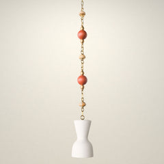 One of a kind cream pendant light with a sculptural hourglass shade hanging from a brass beaded chain, featuring terracotta round beads and light teakwood accent beads, a modern mid century inspired statement pendant for maximalist design lovers, perfect over a kitchen island, breakfast nook, entryway, nursery, or kids room lighting.