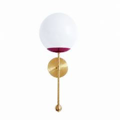A jewel-tone globe sconce for a powder room, bar, or bedside that wants a wall light with some drama. The Verbena Sconce tops a round brass backplate with a slim brass stem, seats a white glass globe in a rich black-cherry cup, and finishes the bottom with a small brass ball, the kind of detail that makes it feel custom. The deep berry-and-brass pairing reads sultry and grown-up, gorgeous flanking a mirror, art, or a bed, especially against moody walls or warm wood. A saturated, glowing light for mid-centur