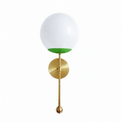 A lively spring-green globe sconce for a powder room, kitchen, or bedside that wants a wall light with fresh, punchy color. The Verbena Sconce tops a round brass backplate with a slim brass stem, seats a white glass globe in a bright grass-green cup, and finishes the bottom with a small brass ball, the kind of detail that makes it feel custom. Green and brass together read fresh and cheerful, striking flanking a mirror, art, or a bed, especially against white trim, botanical wallpaper, or natural wood. A jo