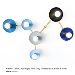 Virgo customizable six-light wall sconce with circular shades in Denim, Hydrangea Blue, Grey, Celestial Blue, Black, and Navy, joined by Brass arms. The asymmetrical design traces the Virgo zodiac constellation, combining colorful modern lighting, astrology-inspired decor, and functional wall art.