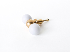 White and brass double gumball drawer pull, shown at an angle with mounting screw visible. A simple, versatile detail suited to furniture makeovers, built-ins, kitchens, kids' spaces, and offices alike.