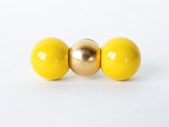 A head-on detail shot of the same brass and yellow double-ball knob, showing the finish and proportions clearly before installing it. Useful for checking scale and color against your own cabinetry.