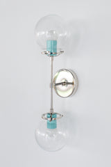 Cadiz double globe wall sconce in poolside blue and polished chrome with clear glass globe diffusers, modern bathroom vanity lighting with a soft warm glow, a colorful contemporary sconce for kids bathrooms, powder rooms, or playful design-forward spaces that need clean lines and bright color