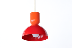 This is color confidence in a single fixture: a two-tone Taeuber pendant that pairs a glossy orange cup top with a punchy red dome, joined by a warm brass stem. The warm-on-warm combination feels retro, sunny, and a little daring, the kind of statement lighting that turns a kitchen island, breakfast nook, or bar into an instant focal point. Hang one for a jolt of energy or a row for real drama. A great choice for a maximalist, collected home that treats bold color as a neutral and loves a playful, graphic d
