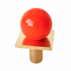 colorful and structural drawer pull features a powdercoated poppy-red color called flame ball on a brass square with a small foot, making it easy to grab as well as gorgeous. Made with real brass, this knob will patina with time if you want it to. 