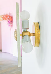 Side View of Botanical Wall Light – A profile shot of a brass and glass wall sconce with intricate pressed foliage designs and a translucent surface.