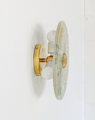 Side View of Botanical Wall Light – A profile shot of a brass and glass wall sconce with intricate pressed foliage designs and a translucent surface.