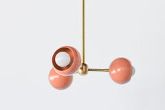 Peach & brass mid century modern style small chandelier with brass hardware and peach powdercoated glossy shade.  Adds a touch of color and style to any small space like a bedroom or bathroom.