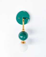 A deep teal-green wall sconce for a bathroom, powder room, or bedroom that wants saturated color with a moody, collected feel. The Ida sconce stacks a glossy green powder-coated sphere over a frosted glass globe, joined by warm brass hardware and a round green backplate. Jewel-toned and confident, it's a standout for eclectic, grandmillennial, English cottage, and colorful traditional homes that skip the safe answer.