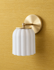 Mustard grasscloth wallpaper brings woven texture and warmth to this wall, and the Marcella Sconce in unglazed cream sits against it as a soft, tonal contrast rather than competing color. The matte fluted shade and brass ball finial keep the look understated and warm, ideal for anyone searching mustard wallpaper ideas or textured walls with quiet, traditional lighting.