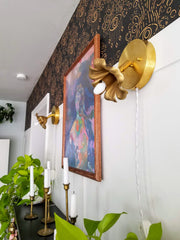 Adjustable floral wall sconce in brass