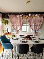 Floral dining room with wallpaper, white painted table, modern chairs, and a Victorian inspired chandelier