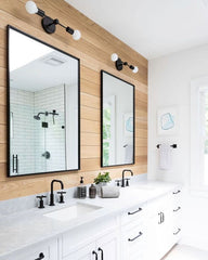 Neutral bathroom with black hardware, black faucet, black wall sconces, white subway tile, and warm wood shiplap