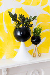 Black and white planters on a yellow background