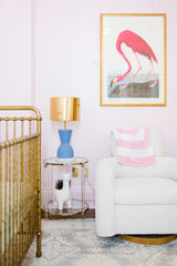 Pink and blue nursery.  Blue lamp on an acrylic and gold side table with pink flamingo Audubon print