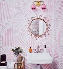 pink and brass bathroom with pink wallpaper, brass mirror, and fun accents
