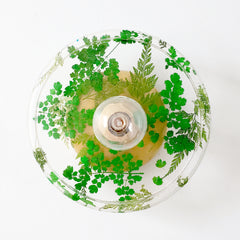 handmade flora wall sconce or flush mount ceiling light with shades of green, brass, and clear resin. front view