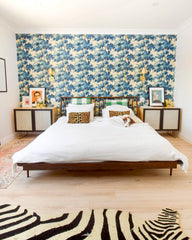 All brass modern wall sconces in a bedroom makeover with floral wallpaper