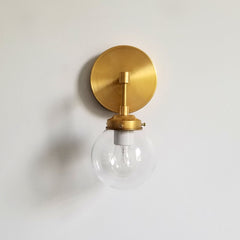 brass wall sconce with clear glass globe light fixture
