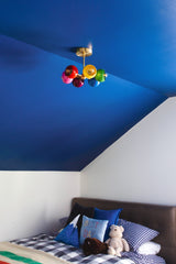 Boys bedroom with blue walls and rainbow chandelier