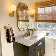 Boho style bathroom with Modern Brass and Glass sconces and art deco mirrors