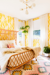 Yellow Guest bedroom with pink accents and modern brass chandelier