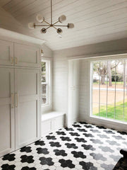 Modern Farmhouse with Brass Carousel with glass chandelier over a black and white hexagon tile floor and in aroom with built in cabinetry, and shiplap walls.  Southern Traditional style space