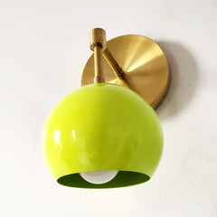 chartreuse green and brass mid century modern inspired wall sconce from a side angle