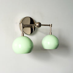 Mint and chrome two light wall sconce that is midcentury modern inspired