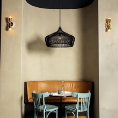 Neutral interior design featuring leather booth, limewash walls, black pendant, and brass and white sconces