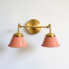 Peach and Brass Double Kelly Sconce features colorful shades and a raw brass finish modern bathroom lighting