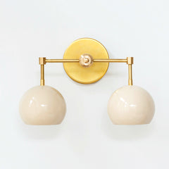 Cream and brass mid century modern two light wall sconce by Sazerac stitches