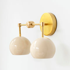 Cream and brass mid century modern two light wall sconce by Sazerac stitches side view