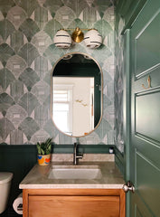 boho-inspired handmade wall sconce with speckled shades, black lines, and more. In a traditional style bathroom with green trip and patterned wallpaper