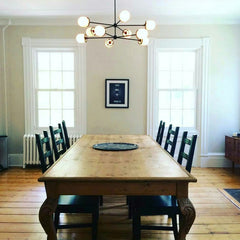 Black Napoleon chandelier with glass over a farmhouse table