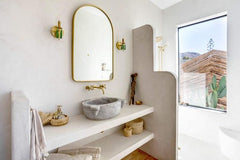 Desert style bathroom with prytania wall sconces