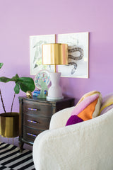 pale lavender and brass table lamp in a pastel purple living room with boucle chairs, chinoiserie decor, and modern black and white art