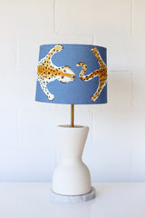 Cream and marble table lamp with brass details and a blue leopard lampshade