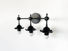 modern black floral three light wall sconce with romanti flowers.  Great black wall sconce for traditional modern or eclectic design bathrooms.  Goes with bright colors and neutrals equally well - side view