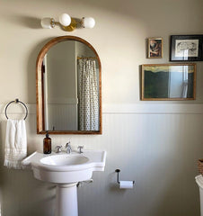 Neutral traditional bathroom design with brass and white wall sconce