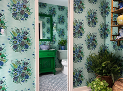 Grandmillenniel preppy modern bathroom decor featuring a green vanity and mirror, mint lighting, and a floral patterned wallpaper