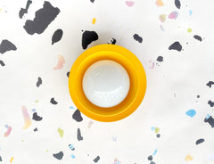 mustard wall sconce inspired by 60s and 70s mod design on a terrazzo printed wallpaper