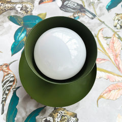 olive green mid century modern wall sconce or flushmount ceiling light on tropical wallpaper