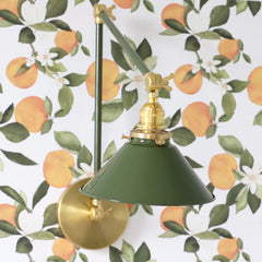 Olive and Brass adjustable sconce on orange blossom wallpaper side view