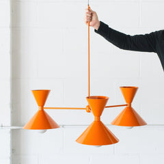 Bright orange mid century modern inspired chandelier made in New Orleans by Sazerac Stitches