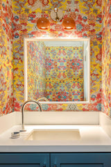 Colorful Bathroom with yellow wallpaper and Orange Double Loa sconce